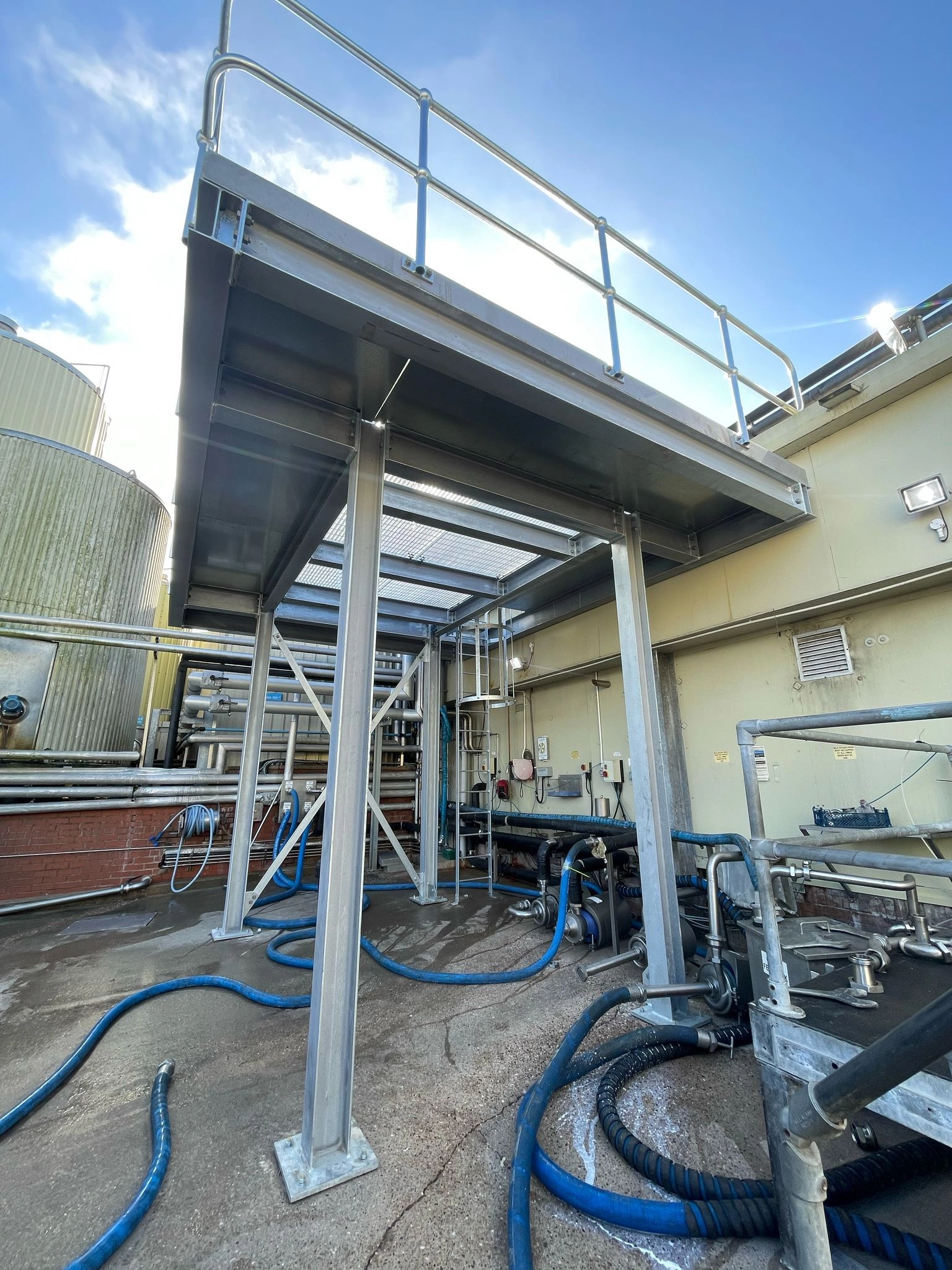 A four-pillar galvanized service platform with walk rails