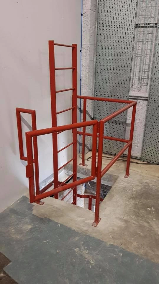 Powder-coated red access ladder with protective guard surround