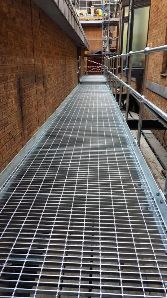 Fully installed galvanized walkway platform complete with handrail