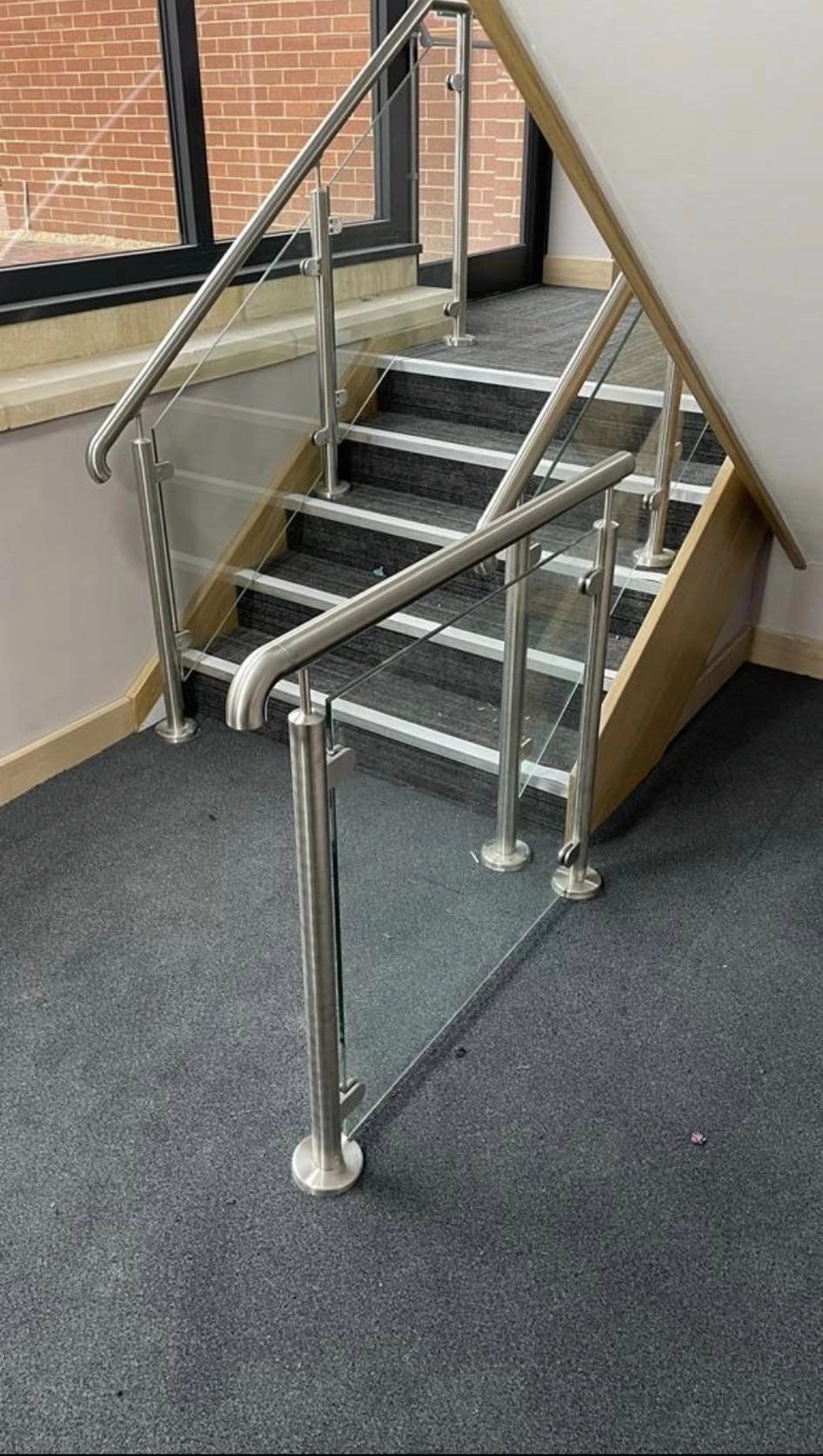 A picture showing a glass and stainless steel handrail with side balustrade.
